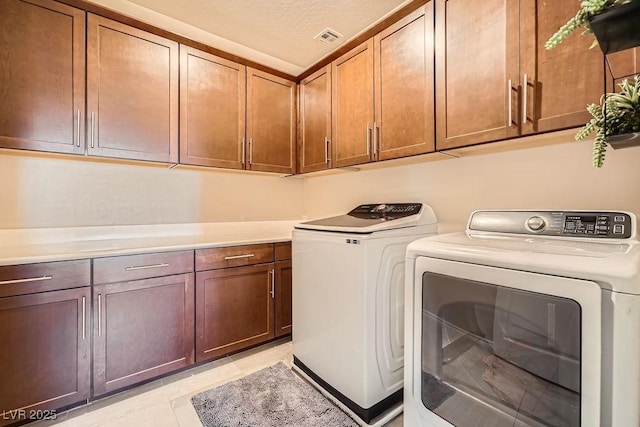 laundry room with independent washer and dryer, visible vents, light tile patterned floors, and cabinet space