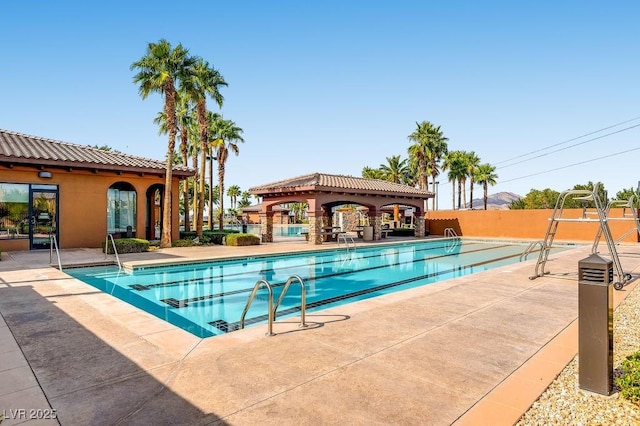 pool featuring fence and a patio area