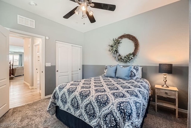 carpeted bedroom with a ceiling fan, baseboards, visible vents, and a closet
