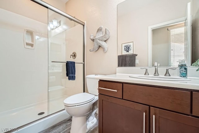 full bathroom with toilet, a shower stall, and vanity