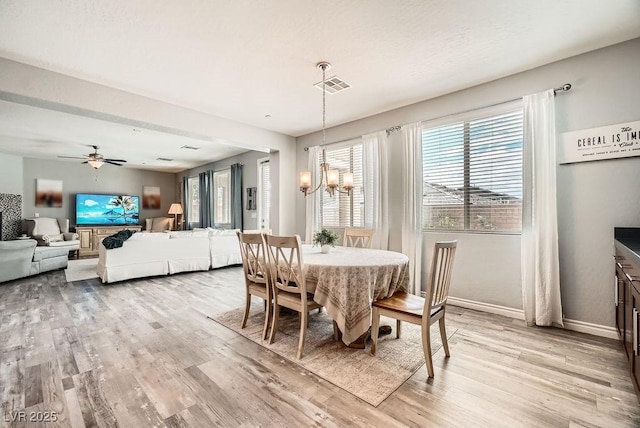 dining room featuring baseboards, ceiling fan with notable chandelier, light wood-style flooring, and visible vents