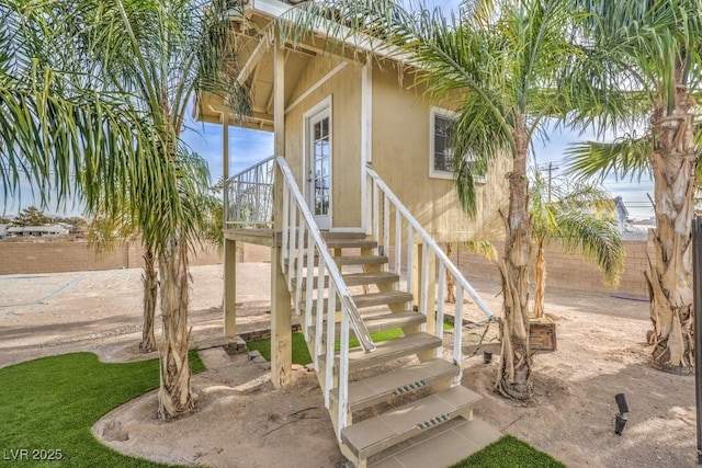 view of exterior entry featuring fence