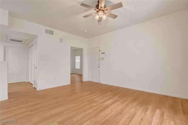 spare room with light wood-style floors, a ceiling fan, baseboards, and visible vents