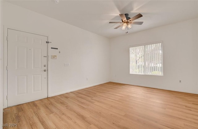spare room with a ceiling fan, baseboards, and light wood-type flooring