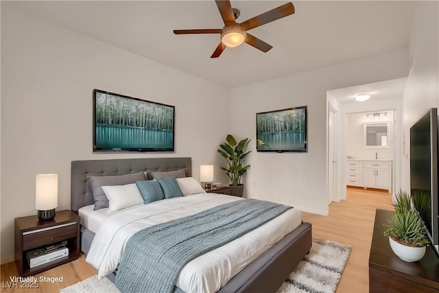bedroom featuring connected bathroom, light wood finished floors, and a ceiling fan