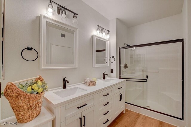 9303 Gilcrease Ave Unit 1245, Las Vegas, NV 89149 - bathroom with visible vents, wood finished floors, a shower stall, and a sink