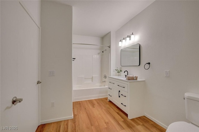 bathroom featuring shower / tub combination, wood finished floors, vanity, baseboards, and toilet
