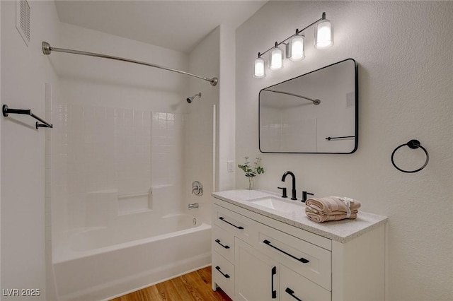 bathroom with vanity, washtub / shower combination, and wood finished floors