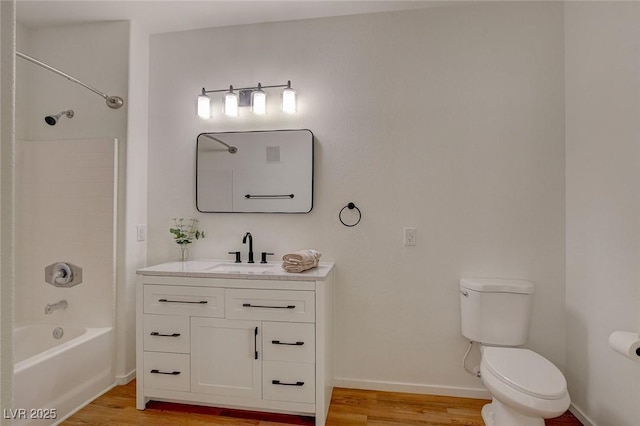 full bathroom featuring wood finished floors, shower / washtub combination, vanity, baseboards, and toilet