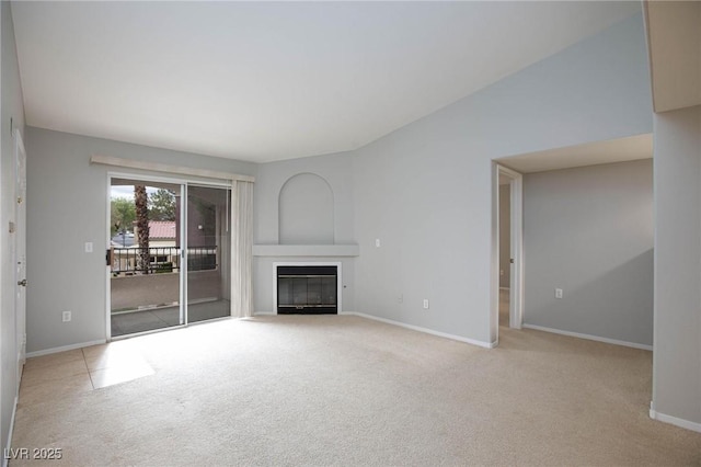 unfurnished living room with a glass covered fireplace, baseboards, and carpet