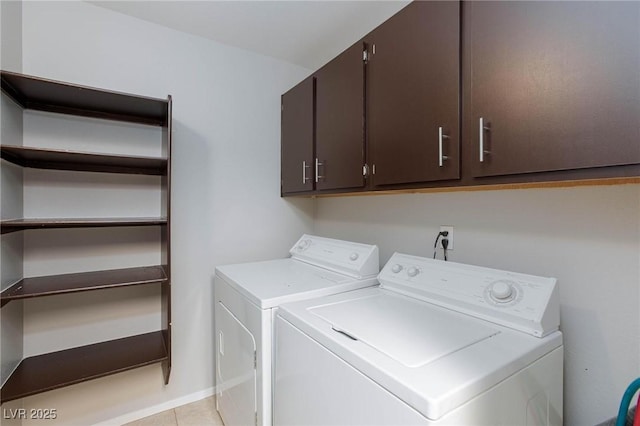 washroom with cabinet space, light tile patterned flooring, and washing machine and dryer