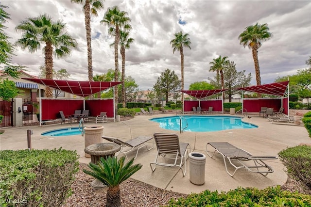community pool with a patio area and fence
