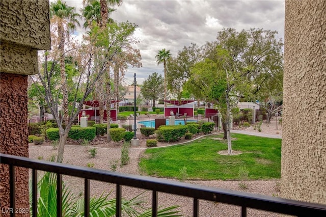 view of home's community featuring a lawn and fence