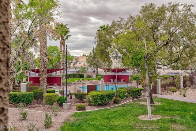 view of property's community featuring fence and a yard