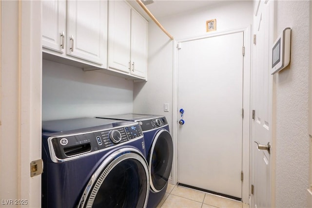 8504 W Gilmore Ave, Las Vegas, NV 89129 - laundry area featuring cabinet space, washing machine and dryer, and light tile patterned floors