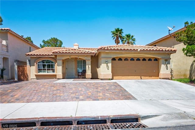 8504 W Gilmore Ave, Las Vegas, NV 89129 - mediterranean / spanish-style house with stucco siding, driveway, a tile roof, an attached garage, and a chimney