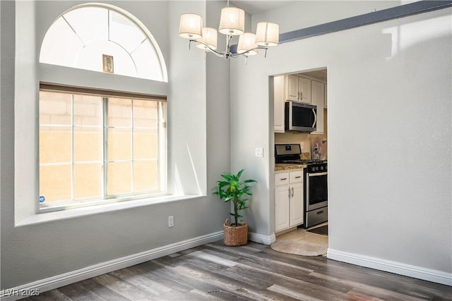 8504 W Gilmore Ave, Las Vegas, NV 89129 - unfurnished dining area with wood finished floors, a chandelier, and baseboards
