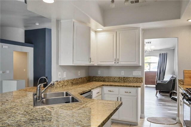 8504 W Gilmore Ave, Las Vegas, NV 89129 - kitchen featuring a sink, white cabinetry, and light stone countertops