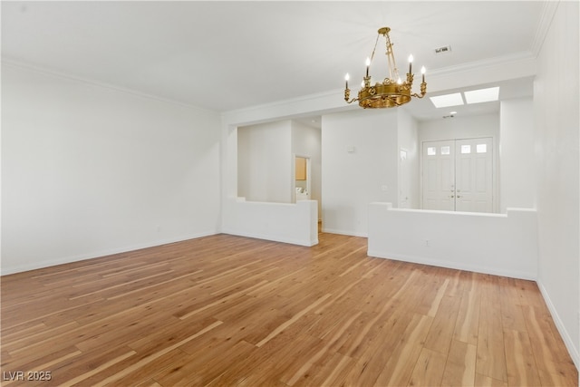 empty room featuring baseboards, ornamental molding, light wood-style flooring, and a notable chandelier