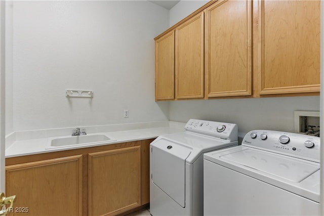 washroom featuring a sink, cabinet space, and washer and clothes dryer