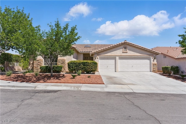 mediterranean / spanish-style house featuring a tile roof, a garage, concrete driveway, stone siding, and stucco siding