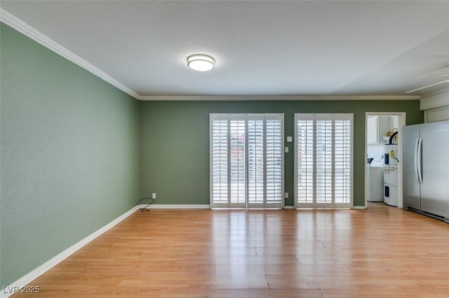 516 Delfern Ln, Las Vegas, NV 89169 - spare room with ornamental molding, light wood-style flooring, baseboards, and washer / dryer