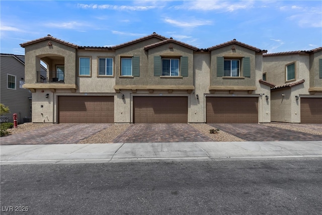 view of front of home with a garage, stucco siding, and driveway