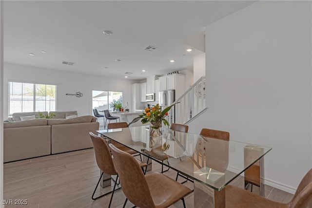 dining space with visible vents, recessed lighting, light wood-style floors, and stairway