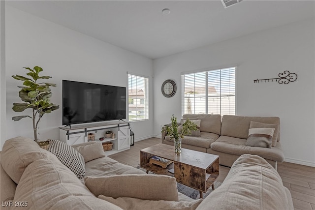 living area featuring light wood-style floors and baseboards