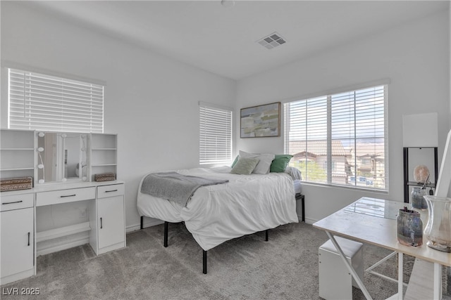 bedroom featuring baseboards, light carpet, and visible vents