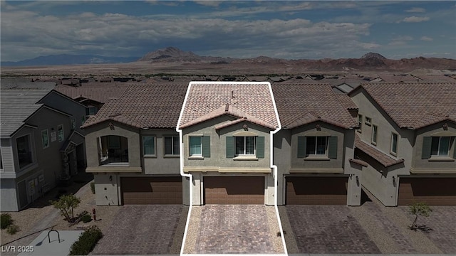 view of front of property with a garage, a mountain view, stucco siding, and a tile roof
