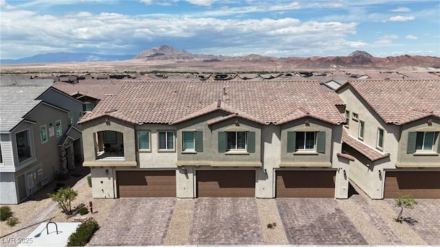 view of front of house with a mountain view, stucco siding, and driveway