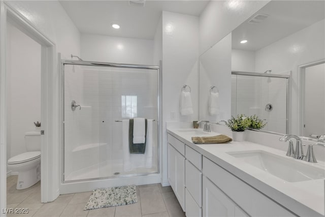 bathroom featuring a sink, a shower stall, and toilet