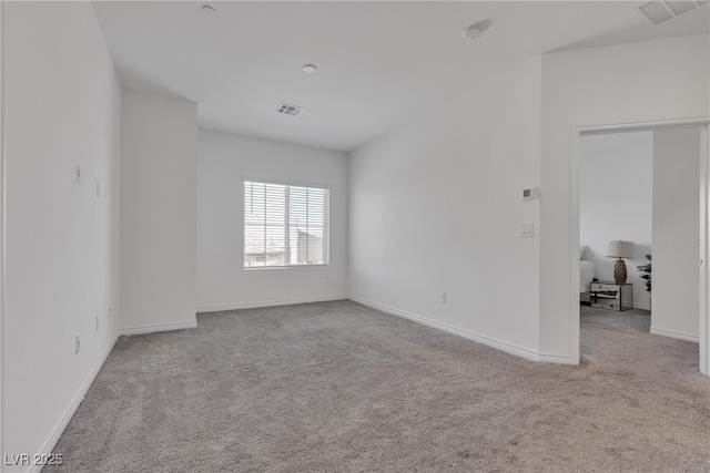 spare room featuring visible vents, baseboards, and carpet floors