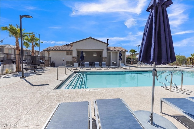 community pool featuring fence and a patio area