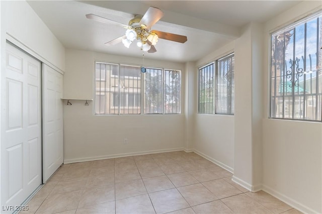 unfurnished bedroom featuring light tile patterned floors, baseboards, multiple windows, and a closet