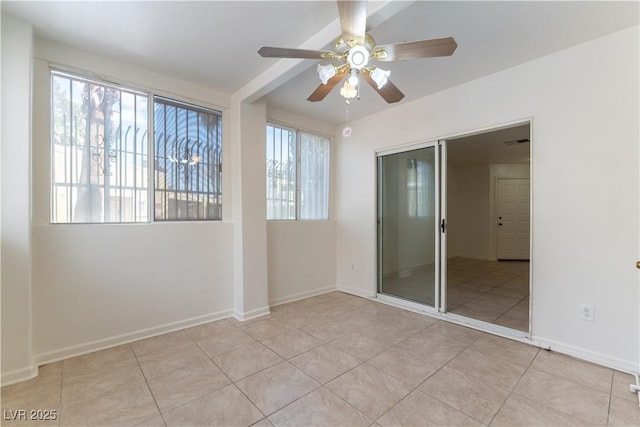 tiled spare room featuring baseboards, ceiling fan, and visible vents
