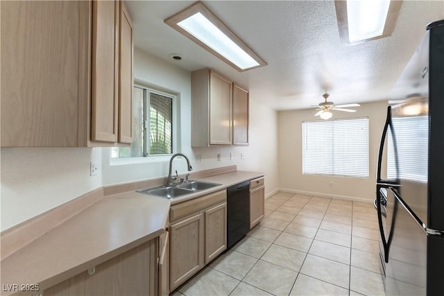 kitchen featuring a sink, black appliances, a wealth of natural light, and light countertops
