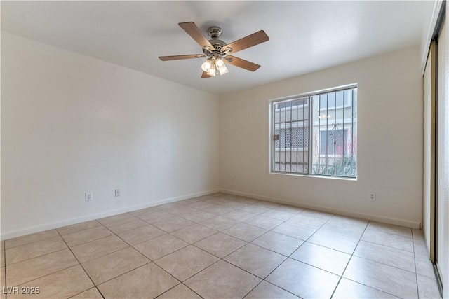 empty room with a ceiling fan, baseboards, and light tile patterned floors