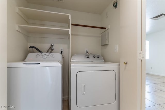 laundry room with laundry area, visible vents, washing machine and clothes dryer, baseboards, and light tile patterned flooring