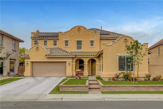 mediterranean / spanish-style home with a garage, stucco siding, concrete driveway, and solar panels