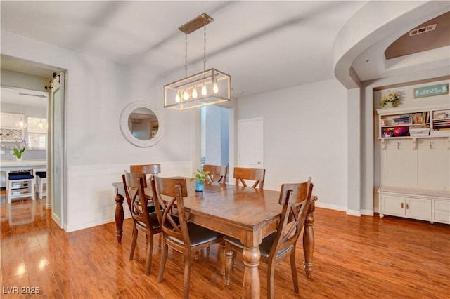 dining room with visible vents, baseboards, and wood finished floors