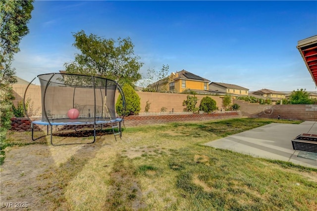 view of yard with a patio, a fenced backyard, and a trampoline