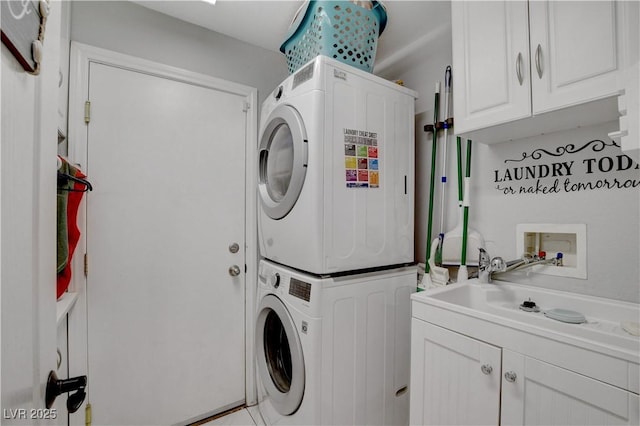 washroom with stacked washer and dryer and cabinet space