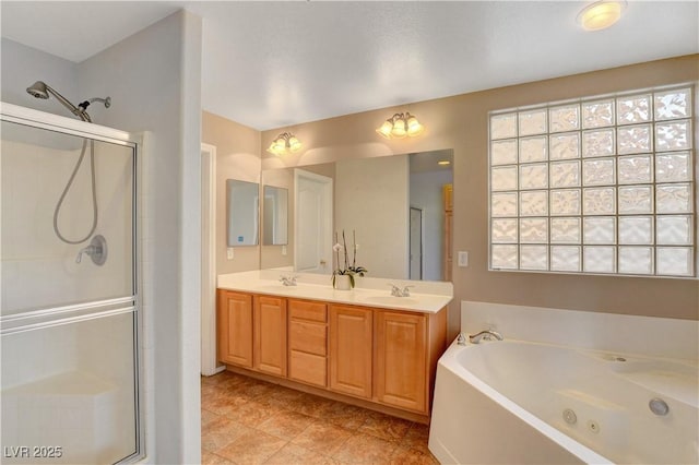 full bath featuring a jetted tub, a stall shower, and a sink