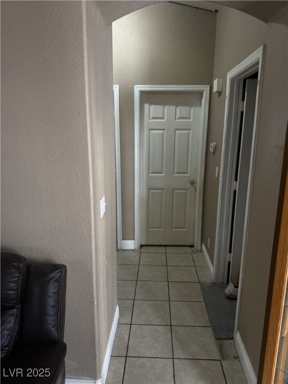 hall with light tile patterned floors and baseboards