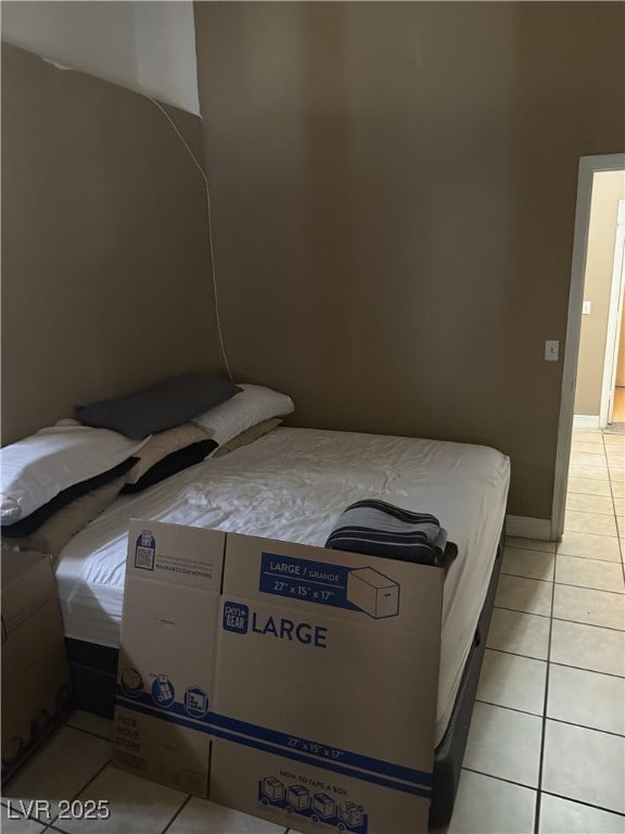 bedroom featuring light tile patterned floors and baseboards