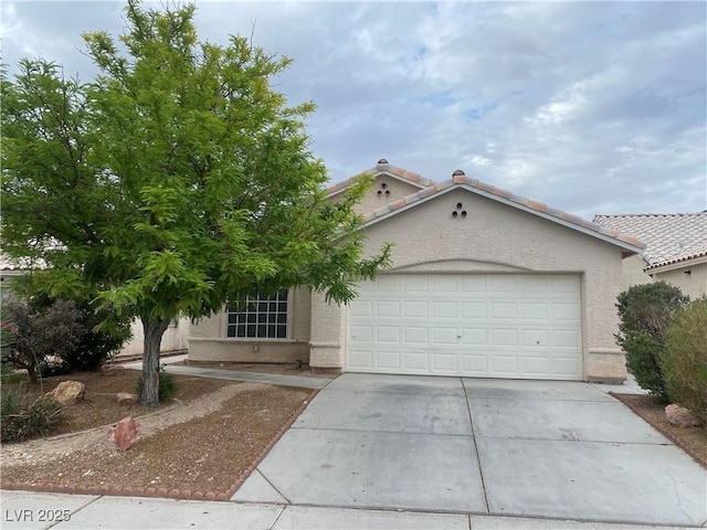 4607 Chestnut Blaze Dr, North Las Vegas, NV 89032 - mediterranean / spanish house with driveway, an attached garage, a tile roof, and stucco siding