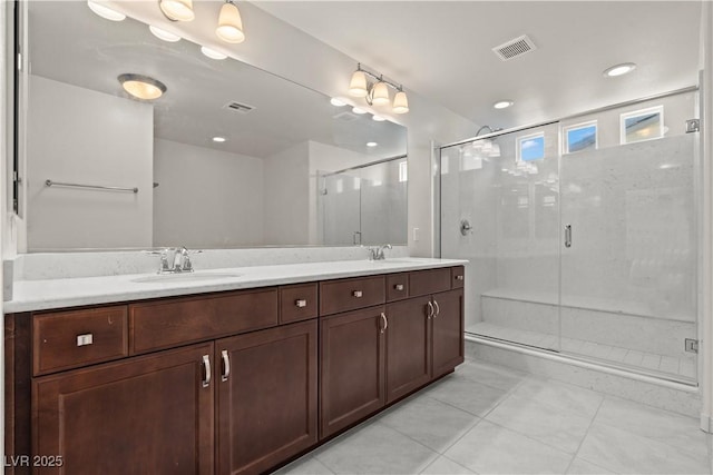 full bathroom featuring double vanity, tile patterned floors, visible vents, and a sink