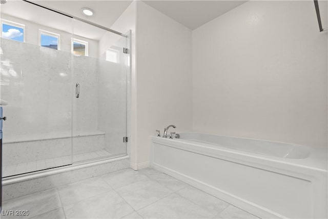 full bathroom featuring baseboards, a garden tub, and a stall shower
